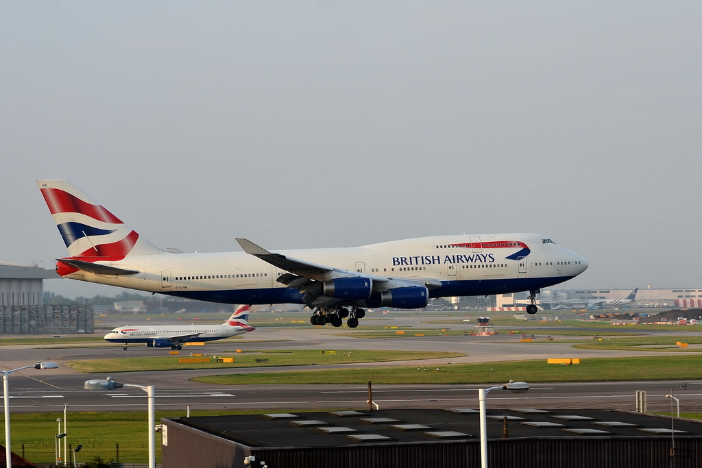 British Airways, G-CIVN, Boeing 747-436. Der Jumbo von BA kurz vor dem touchdown. Im Hintergrund rollt ein A320 von British Airways zum Start. 31.7.2011