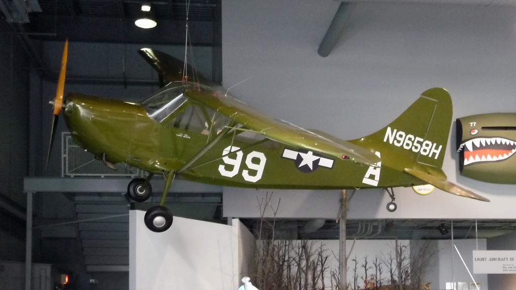 Seitansicht auf das Verbindungsflugzeug  L-5E Stinson Sentinel  im EAA Museum Oshkosh, WI (3.12.10). Es wurde auch  fliegender Jeep  genannt. Das Flugzeug hat hervorragende STOL-Fhigkeiten, bentigt kaum mehr als 30 Meter Bahn zum Abheben...