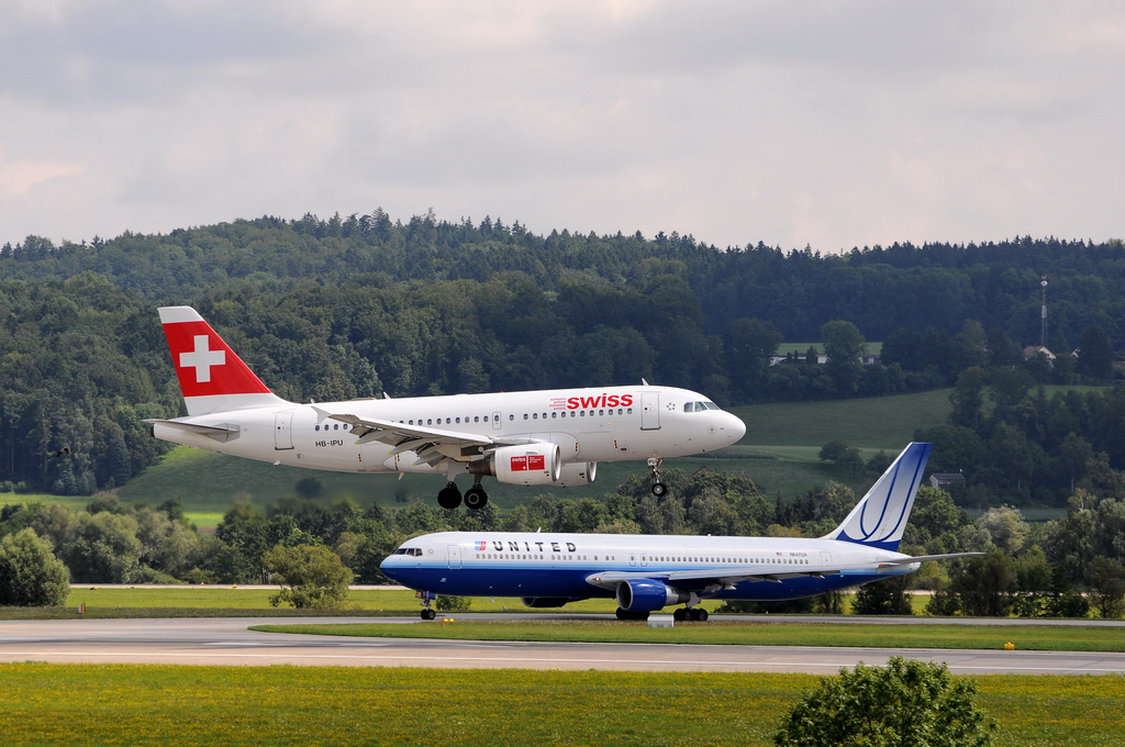 Swiss International Air Lines, HB-IPU, Airbus A319-112. Landung auf der Bahn 16. Im Hintergrund wartet die United B767 auf ihren Start. 6.8.2010 