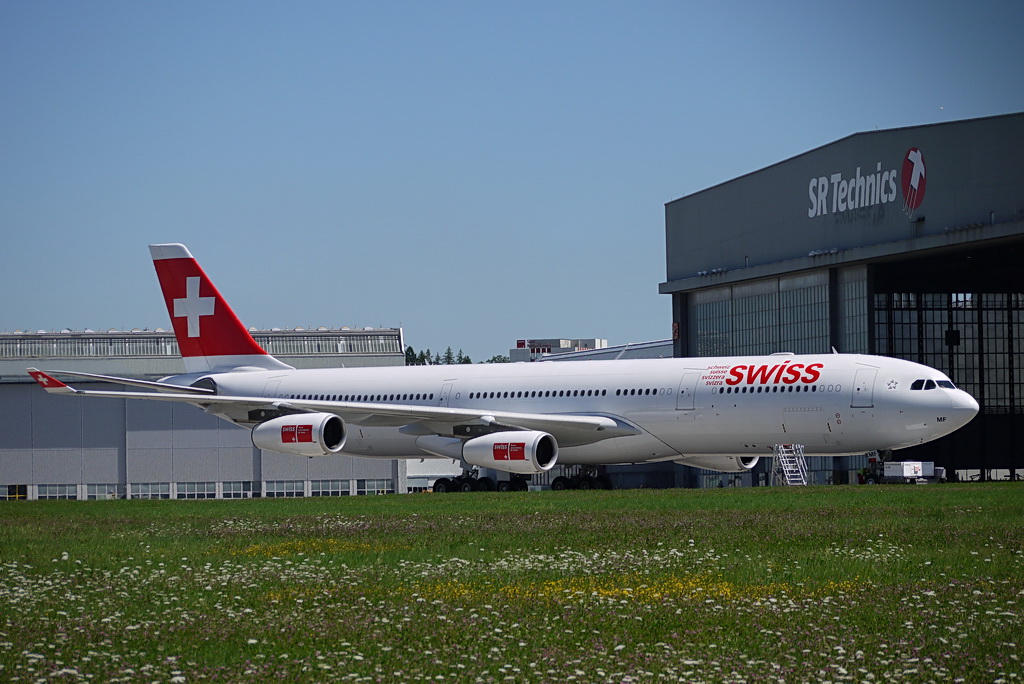 Swiss International Air Lines, HB-JMF, Airbus A340-313X. Der groe Vierstrahler vor der Halle von SR Technics an einem warmen Sommertag am 31.7.2010.