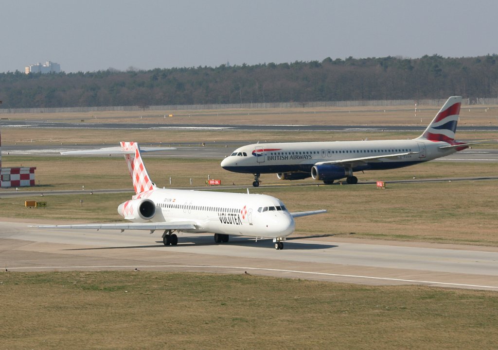 Volotea B 717-2BL EC-LPM auf dem Weg zum Start in Berlin-Tegel am 25.03.2012. Im Hintergrund British Airways A 320-232 G-EUUN
