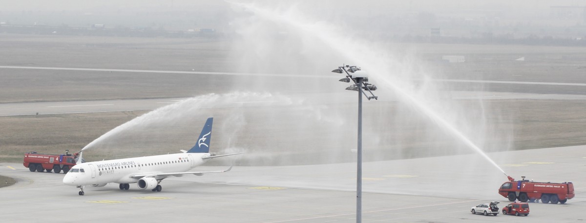 24.3.15 @ LEJ / Montenegro Airlines Embraer-195 4O-AOB bei der Begrüßung durch die Flughafenfeuerwehr