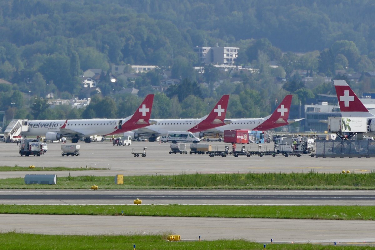 3 Helvetic Flugzeuge und ein Swiss Heckruder die am 15.9.18 in Zürich stehen.