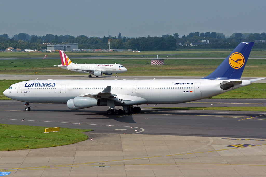 A 340-300  Dinslaken  der Lufthansa, D-AIGV taxy at DUS, dahinter beim Start die A 320-200 Germanwing D-AIPX - 04.09.2014