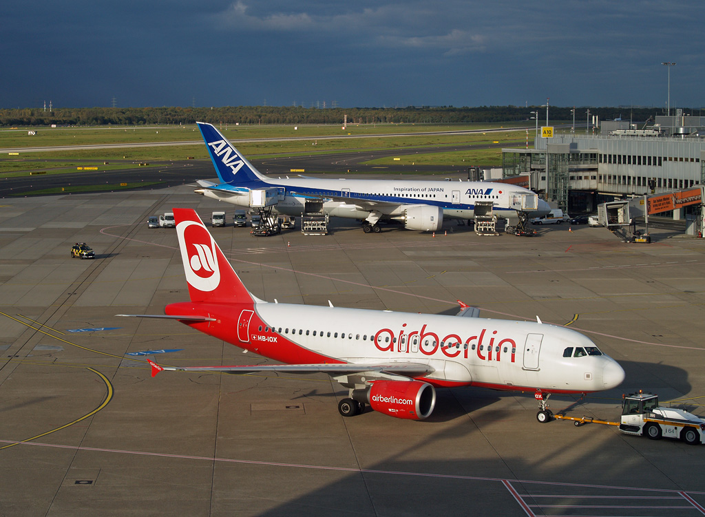 Der A319-112 von Belair wird am 14.10.2014 in Düsseldorf gerade vom Gate zurückgedrückt, um seinen Flug nach Zürich antreten zu können. Der Dreamliner von ANA hat dagegen noch ein paar Stunden Zeit, der Flug nach Tokyo startet erst nach Anbruch der Dunkelheit.