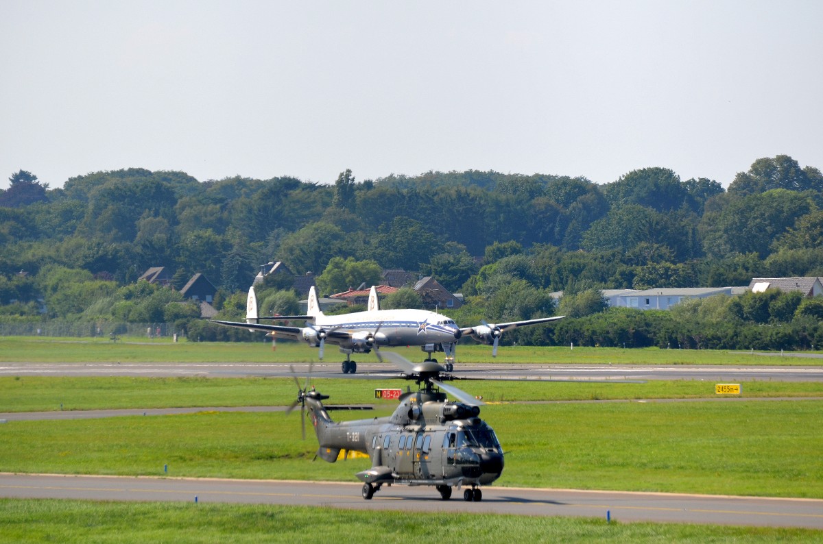 Die Lockheed C-121C Super Constellation HB-RSC beim Start in Hamburg Fuhlsbüttel anlässlich der Hamburg Airport Days am 22.08.15 im Vordergrund der AS-332 M1 Super Puma T-321 der Swiss Air Force.