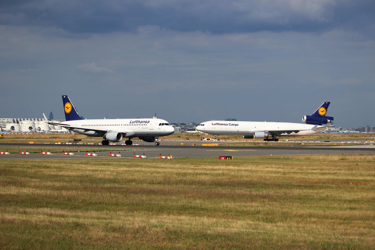 Ein A320 D-AIUO mit Sharklets der Lufthansa beim Start in Frankfurt, im Hintergund befindet sich eine MD-11F D-ALCN der Lufthansa Cargo auf dem weg zum Line-up der Startbahn West. Die Aufnahme entstand am 6.8.16 