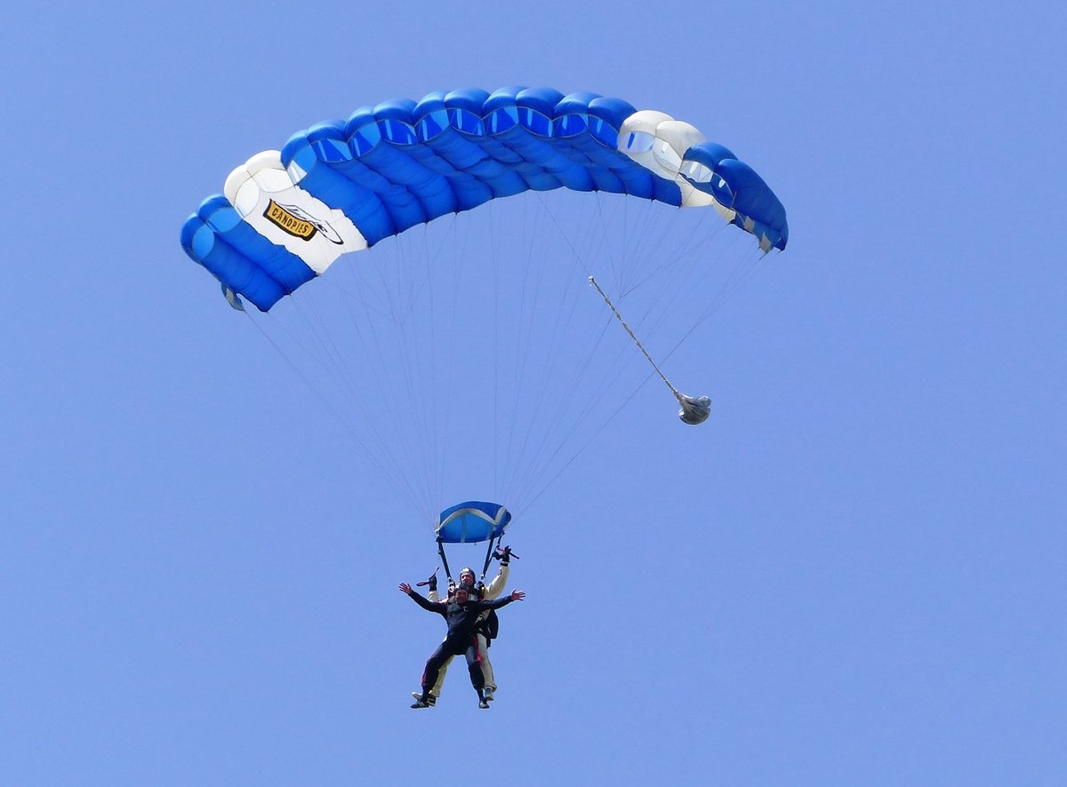 Ein Fallschirm - Tandempaar, von SKY DIVE LEIPZIG, schwebt am einem IKARUS 365 der Erde entgegen. Flugplatz Roitzschjora (EDAW) am 15.7.2017