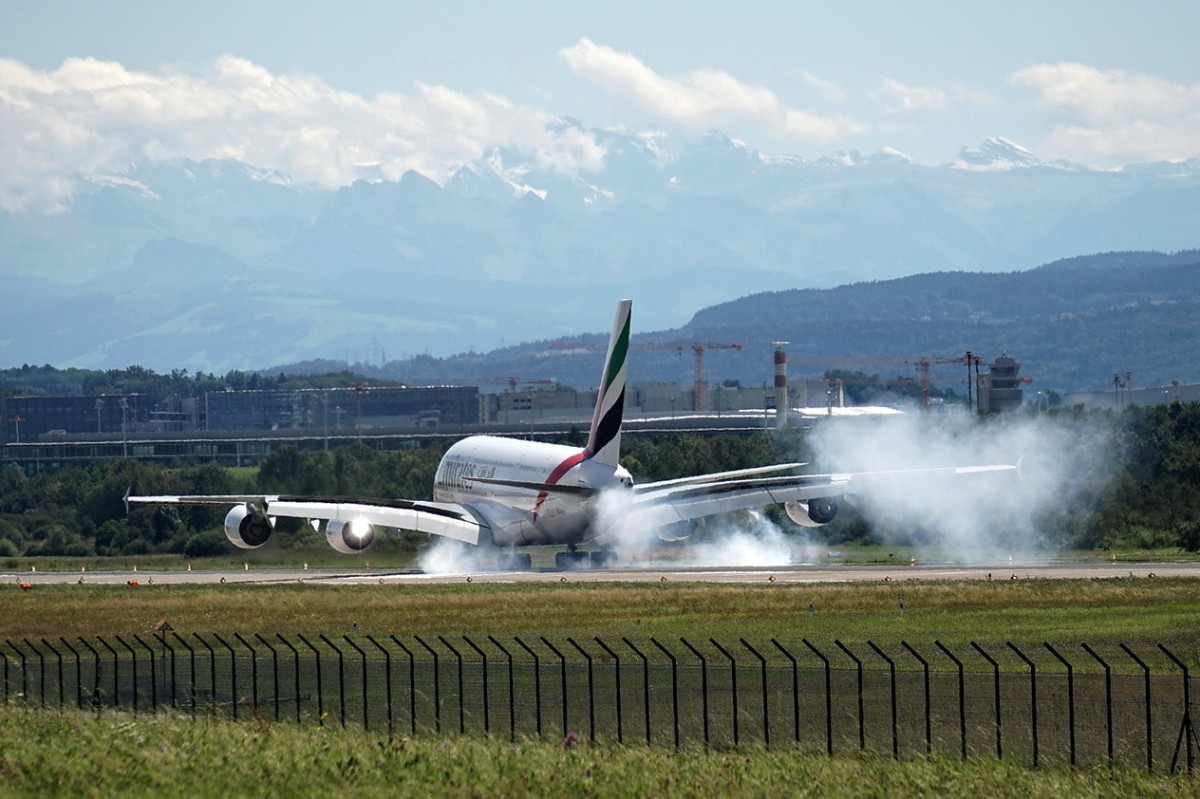 Emirates, A6-EET, Airbus A380-861. Touchdown des Giganten und eine Menge Gummi von den Reifen bleibt auf der Landebahn zurück. 17.8.2014