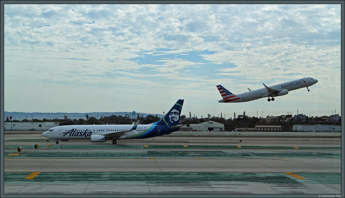 Konkurrenz am Los Angeles International Airport: Links die Boeing 737-890 N597AS der Alaska Airlines, rechts der startende Airbus A321-231 N141NN der American Airlines. (29.10.2016)
