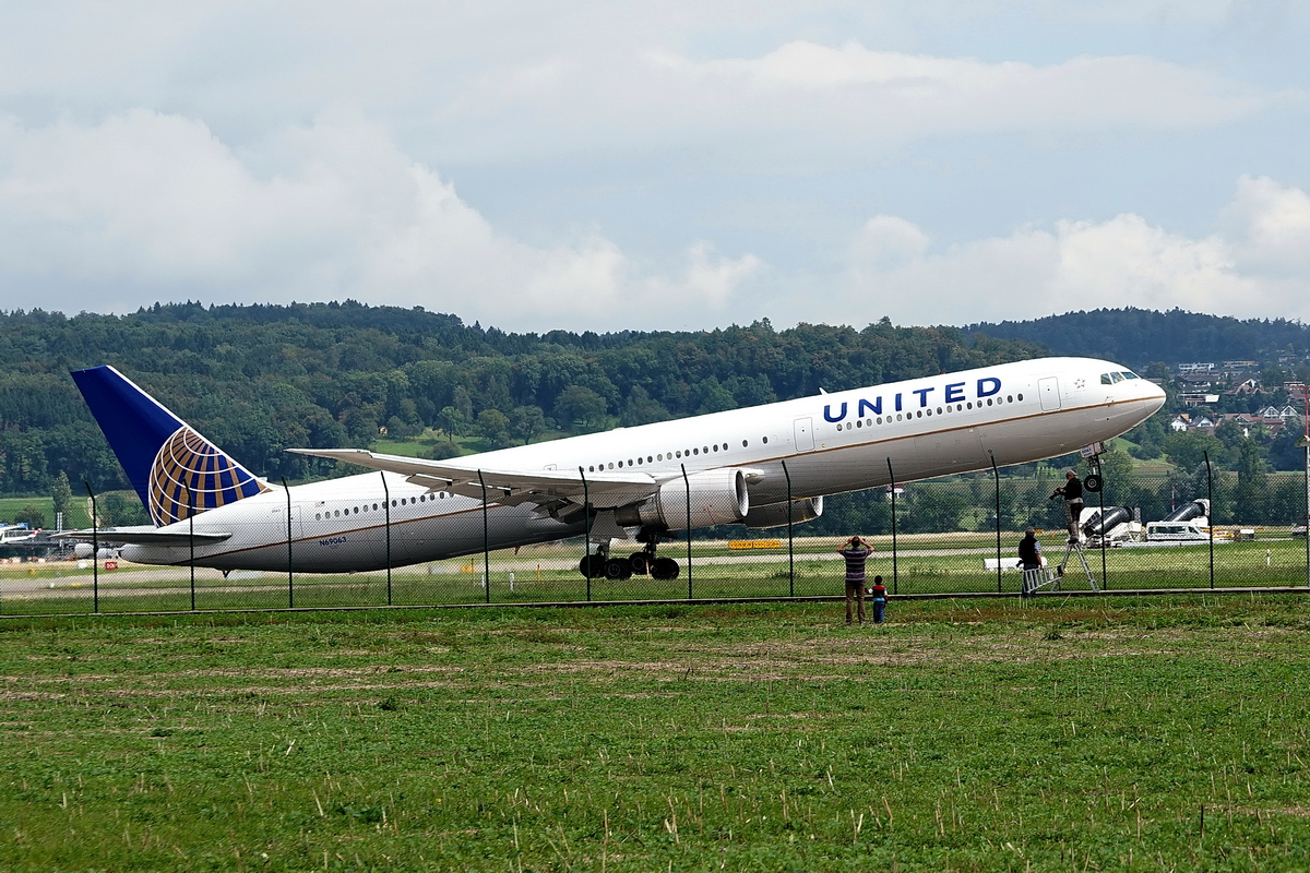 United Airlines, Boeing 767-424/ER, N69063. Die grosse 400er Boeing hebt ab und der Spotter auf der Leiter hat schon vorher seine Fotos gemacht. Für den anderen Spotter war die United Maschine wohl nicht so interessant. 19.8.2014 