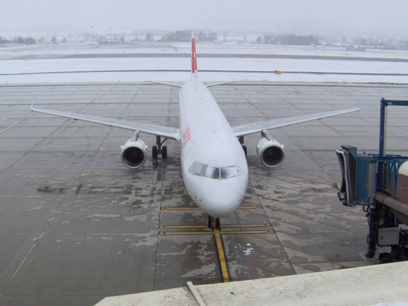 Arbeitslos und leicht verschneit wartet im Winter 2005 eine A 321 der Swiss in Zrich-Flughafen.