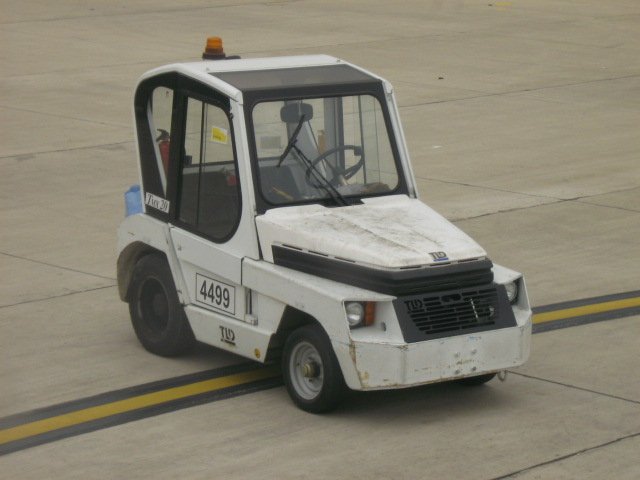 Ein Bild vob einem Gepckwagenzieher am Flughafen in Sevillia.