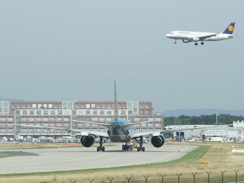 Frankfurt am Main (FRA) am 07.08.2008. Ein Airbus A 320 der Lufthansa landet, whrend eine Vietnam Airlines Boeing 777 auf dem Rollfeld unterwegs ist.