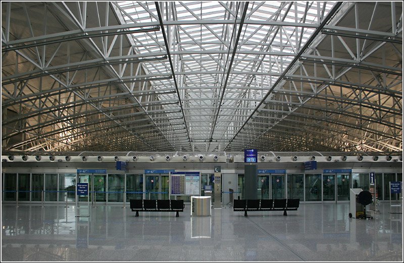 Im Bild der sehr breite Abfahrtsbahnsteig mit Bahnsteigtren des Skytrains im Terminal 2. 1.6.2005 (Matthias)