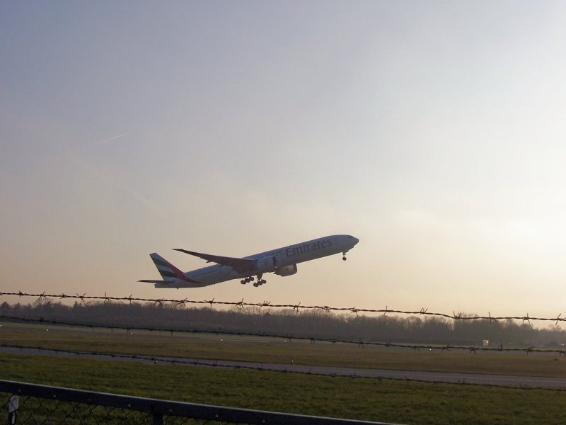 Take Off in der Abenddmmerung ein Boeing 777-300 von Emirates hebt in Hamburg  ab.