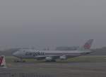 Die Cargolux Boeing 747-4B5 LX-DCV wird am 22.01.2014, bei neblig trbem Wetter, ber das Vorfeld des Flughafens von Luxemburg geschleppt.