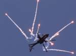 Ein AH-64 stt im Rckenflug eine Ladung Flares aus.