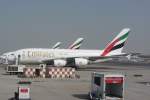 Emirates Airbus A 380-800 (A6-EEC) am Flughafen in Dubai am 15. August 2013 bei der Bereitstellung für einen neuen Flug. Nebenan warten weitere A380. Emirates ist im Besitz von 50 A 380 und hat 90 weitere bestellt. Somit ist die Emirates die Fluglinie, die weltweit am meisten A 380 besitzt.