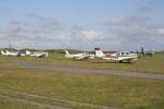 Mehrere Flugzeuge stehen auf dem Abstellfeld des Flugplatzes der ostfriesischen Insel Juist am 15.08.11. Im Hintergrund landet die Britten-Norman Islander D-IFTI der Gesellschaft FLN