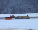 Winterdienst in Friedrichshafen, ein Rumfahrzeuge ist damit beschftig den runway am Flughafen Friedrichshafen von Schnee und Eis zu befreien, ...