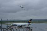 Lufthansa Airbus A380-800 D-AIMA der Lufthansa steht auf seiner Parkposition als �ber ihm eine Boeing 767 der Austrian Airlines gerade gestartet ist. 2.6.2010