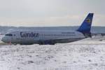 Ein Condor-Berlin-Airbus A320-200 (Zulassung D-AICK) verschwindet hinter einem Schneeberg am ...