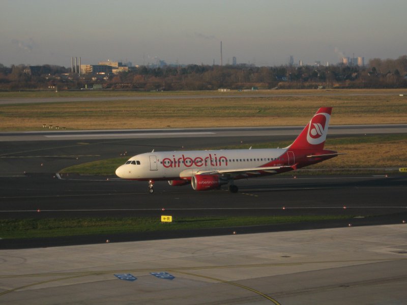 Traumhafter Sonnenschein whrend dieser kleine A319-100 der Air Berlin von der Runway in Richtung Terminal C rollt.