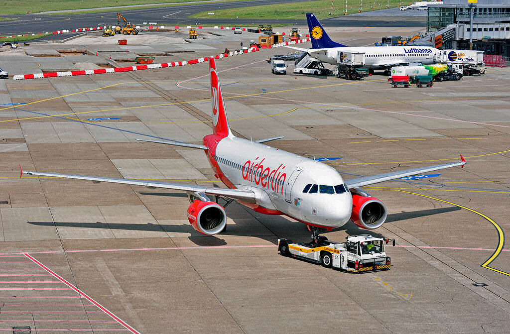 A 319-112 der Air Berlin, D-ABGO,  pushback  in Dsseldorf. Im Hintergrund Boeing 737 der Lufthansa. Dsseldorf 07.06.2010