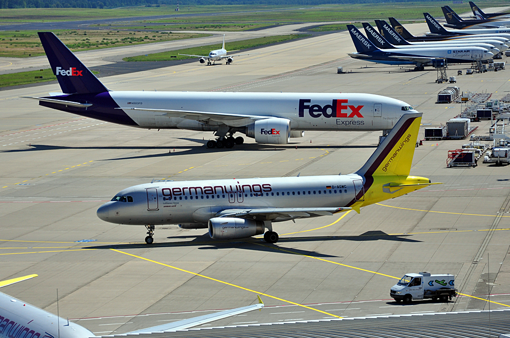 A 319-132 D-AGWC der Germanwings rollt an der B 777-FS2 von FedEx in Kln vorbei - 12.08.2012