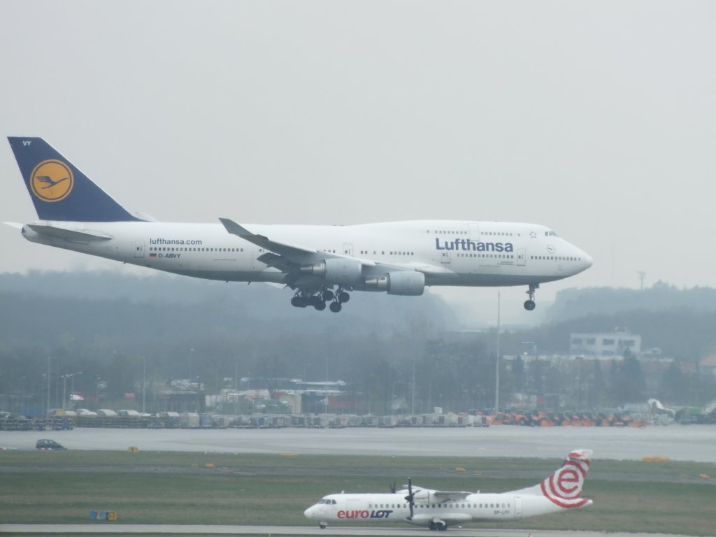 Boeing 747-400 der Lufthansa (D-ABVY) im Landeanflug am Frankfurter Flughafen. Auf dem Taxiway befindet sich eine ATR 72 der Eurolot (SP-LFF); 06.04.12