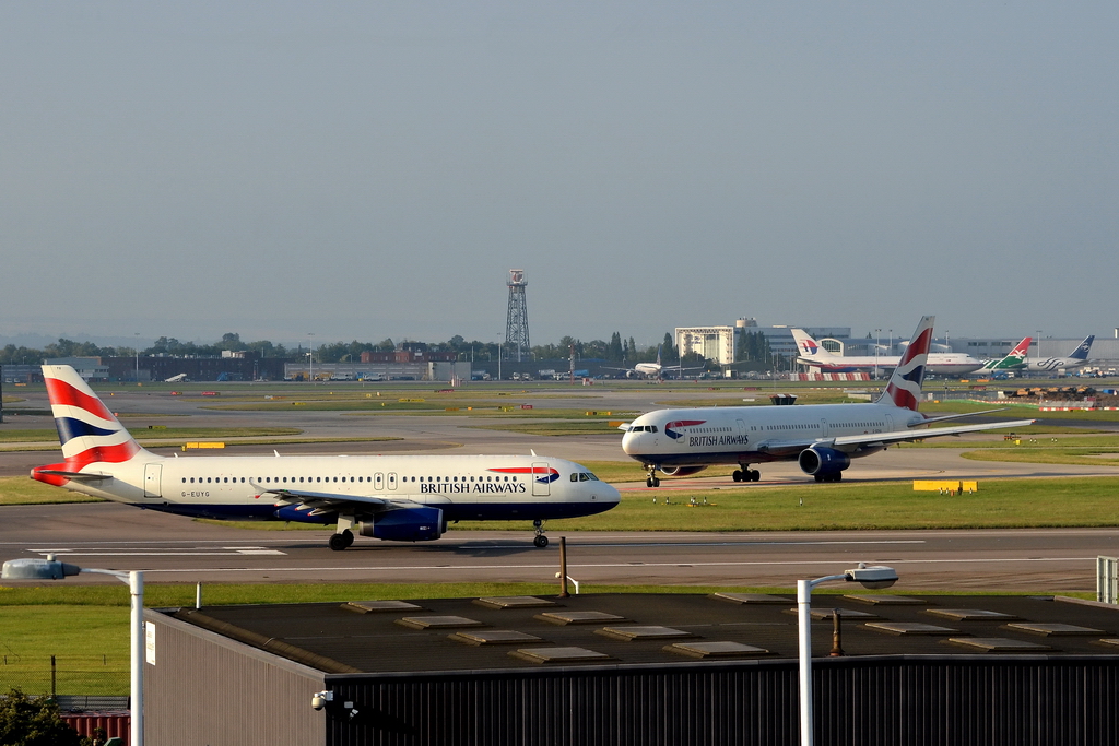 British Airways, G-EUYG, Airbus A320-232. Der kleine Airbus wartet auf die Startfreigabe, whrend dahinter eine Boeing 767 der gleichen Gesellschaft, danach gleich in die Lfte steigen kann. 31.7.2011
