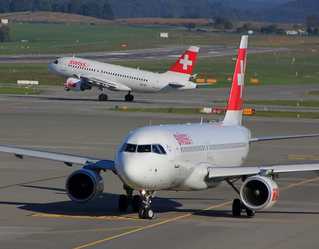 Der Flughafen Zrich, hier ist immer etwas los, eine Swiss wurde gerade vom Gate auf den Taxiway geschoben (Vordergrund), dahinter startet ein A319 von siwss auf runway 28 (06.10.2012)
