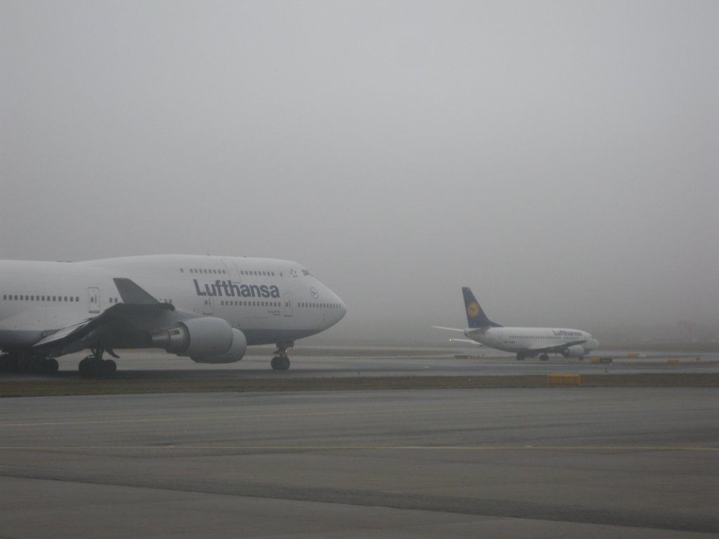 DIE GROSSE UND DIE KLEINE: Eine Lufthansa-Boeing 747-400 und eine Boeing 737-500 unmittelbar vor dem Start auf dem Frankfurter Flughafen am Samstag, den 6. Februar 2010