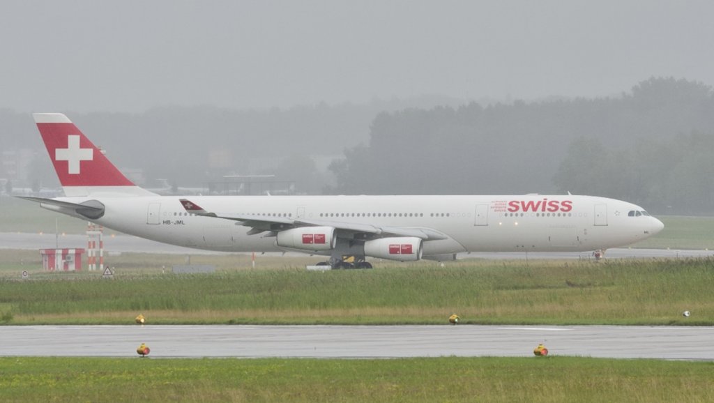 Ein Airbus A340-313 der Swiss wartet auf dem Taxiway, bei Regen, auf dem Flughafen Zrich am 22.07.2011