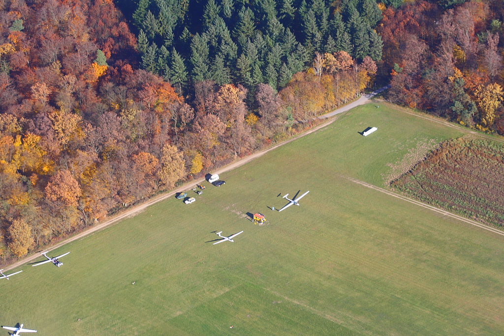 Ein Tei des Flugplatzes Karlsruhe Forchheim (Segelfluggelnde Rheinstetten) aus der Luft. Der gelbe Wagen zwischen den zwei Segelflugzeugen ist der rollende  Tower  des Flugplatzes 