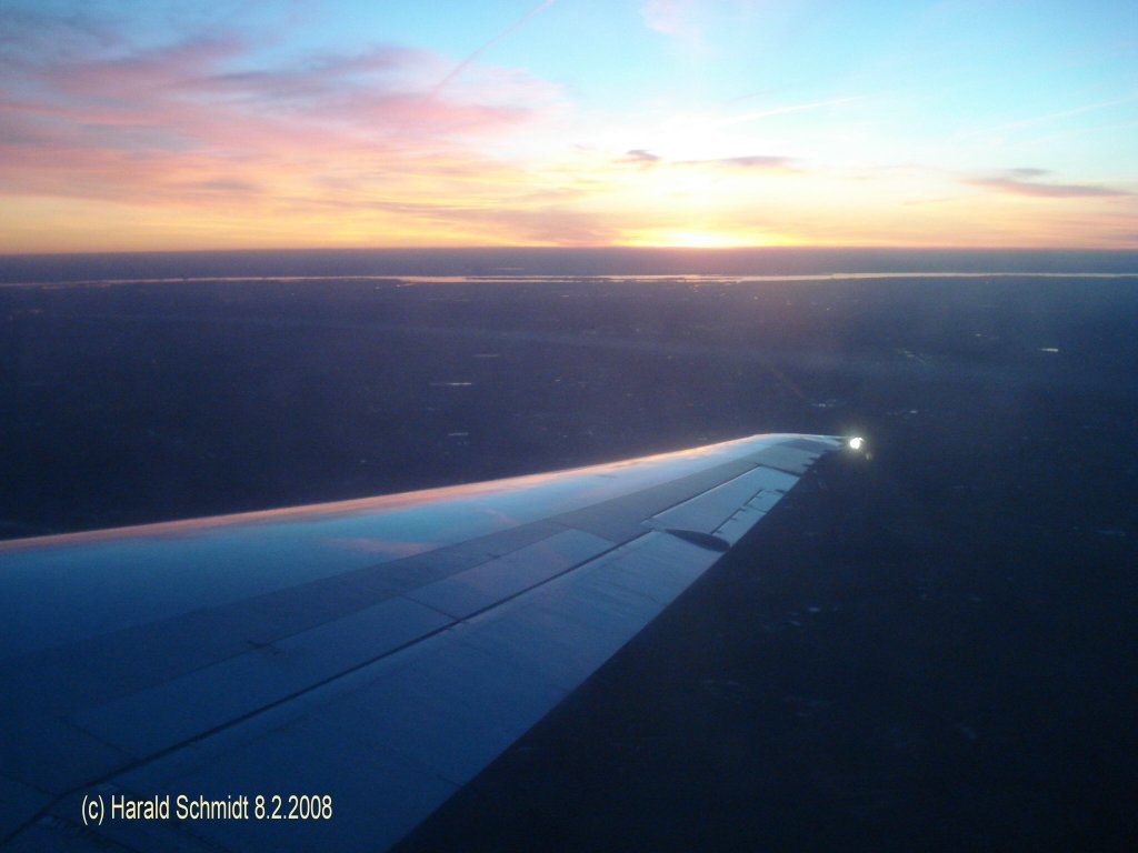 Flug in den Sonnenuntergang am 8.2.2008: von Kopenhagen nach Hamburg, ber Schleswig-Holstein zu Landung in Hamburg von Westen her, das silberne Band am Horzont ist die Elbe.