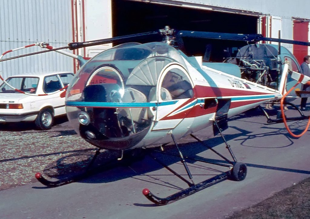 Fr Hubschrauberspezialisten, 2 seltene  Vgel , einmal im Vordergrund der Brantly B2B (D-HIDE), auch  Eistte  genannt, und im Hintergrund eine Bell 47 H (mit verkleideter Kabine, sehr wenige gebaut) D-HABE - Offenburg Mitte der 70iger Jahre - Scan vom Kleinbilddia