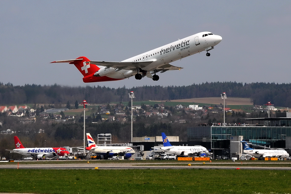 Helvetic Airways, HB-JVE, Fokker 100. Die kleinen Maschinen gewinnen schnell an Hhe. Die Besucherterrasse (rechts) lehrt sich langsam, denn der Airbus A380 ist schon 30 Minuten vorher gestartet. 10.4.2010 