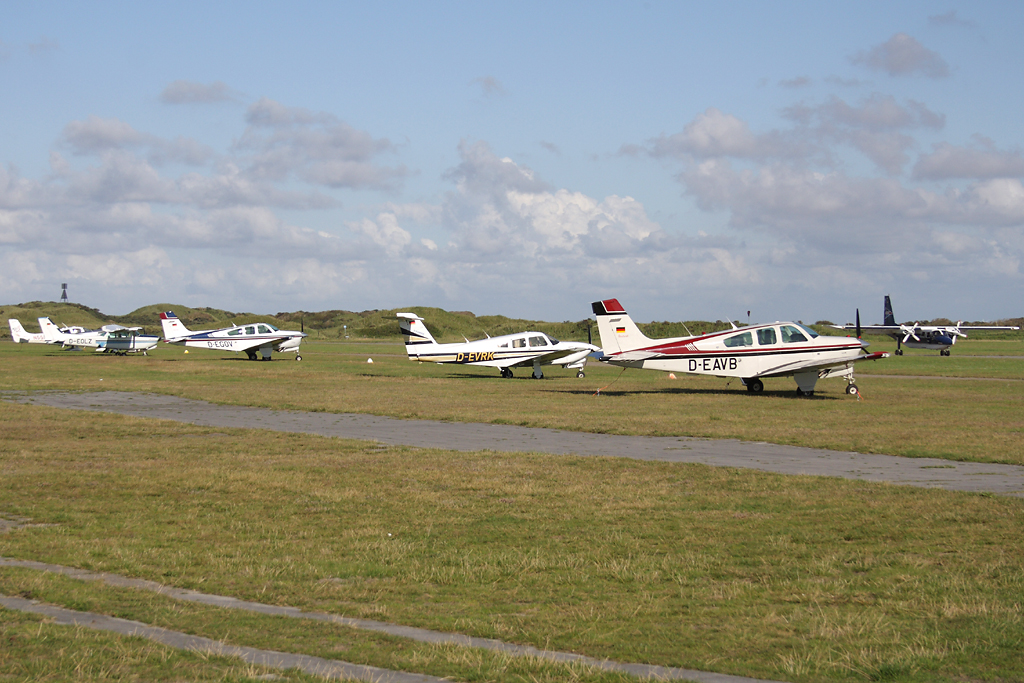 Mehrere Flugzeuge stehen auf dem Abstellfeld des Flugplatzes der ostfriesischen Insel Juist am 15.08.11. Im Hintergrund landet die Britten-Norman Islander D-IFTI der Gesellschaft FLN