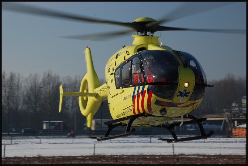 Rettungshubschrauber 'Lifeliner 2' PH-ULP startet von einem Feld, nachdem die Bemannung bei einem Unfall geholfen hat; Ridderkerk, den 6. Januar 2010.