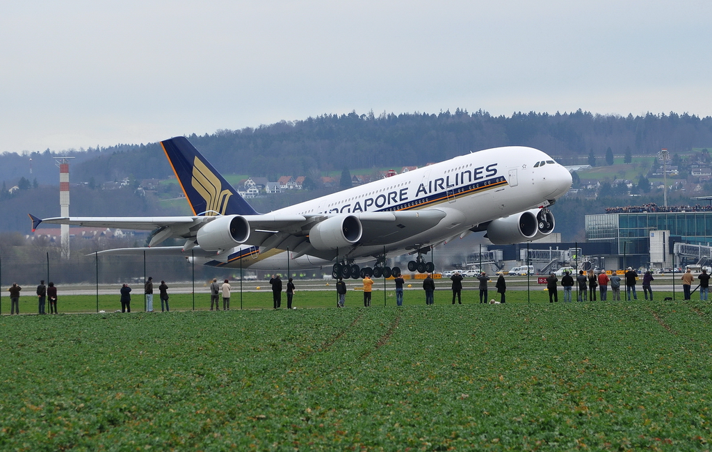 Singapore Airlines, 9V-SKJ, Airbus A380-841. Ein gewaltiger Anblick dieser Riesenvogel. Die Zuschauerterrasse,rechts in der Mitte, ist voller begeisterter Zuschauer. 30.3.2010 