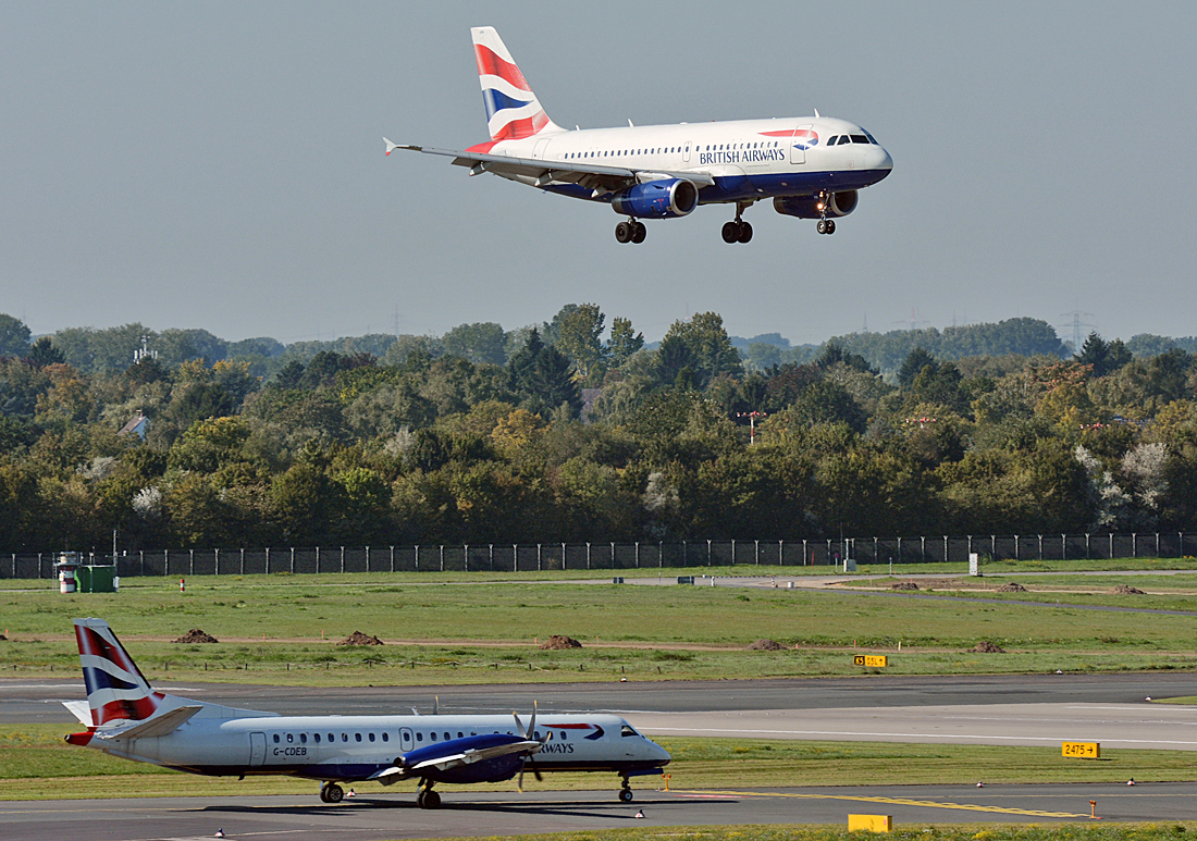 2 x British Airways, im Landeanflug A 319-131 G-EUPR und auf dem Rollweg eine Saab 2000 G-CDEB in Düsseldorf - 01.10.2015