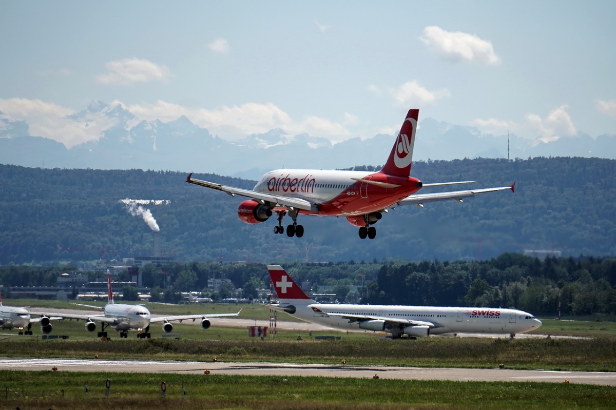 Air Berlin, HB-IOX, Airbus A319-112. Einer landet, die Anderen wollen in die Luft gehen. Im Hintergrund sind auch mal wieder die Alpen zu sehen. 17.8.2014