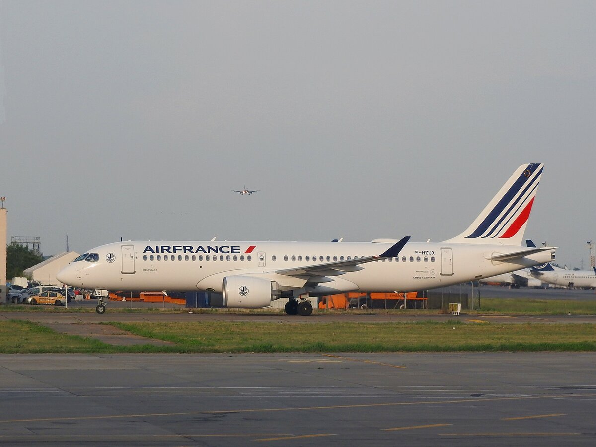Airbus A220-300 von Air-France mit Kennung F-HZUX; wartet im Flughafen  Bukarest Henri Coandă (früher Bukarest-Otopeni) auf die Starterlaubnis, während im Hintergrund ein Landevorgang von Statten geht; 230706