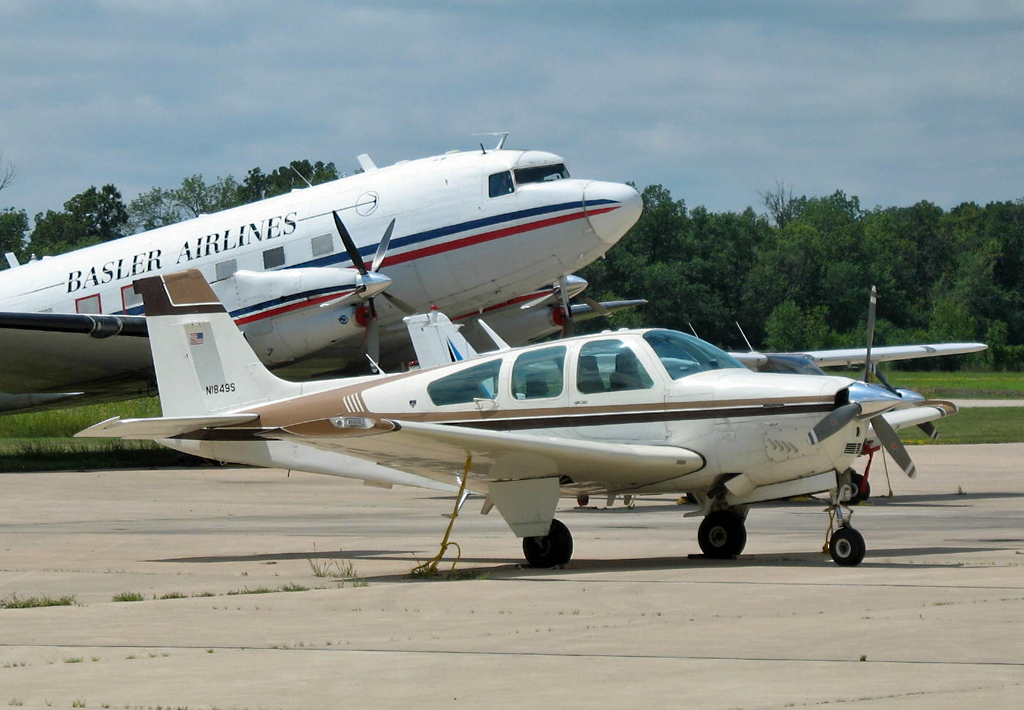 Beech F 33 A, N1849S, dahinter eine DC-3 in Oshkosh 26.07.2014