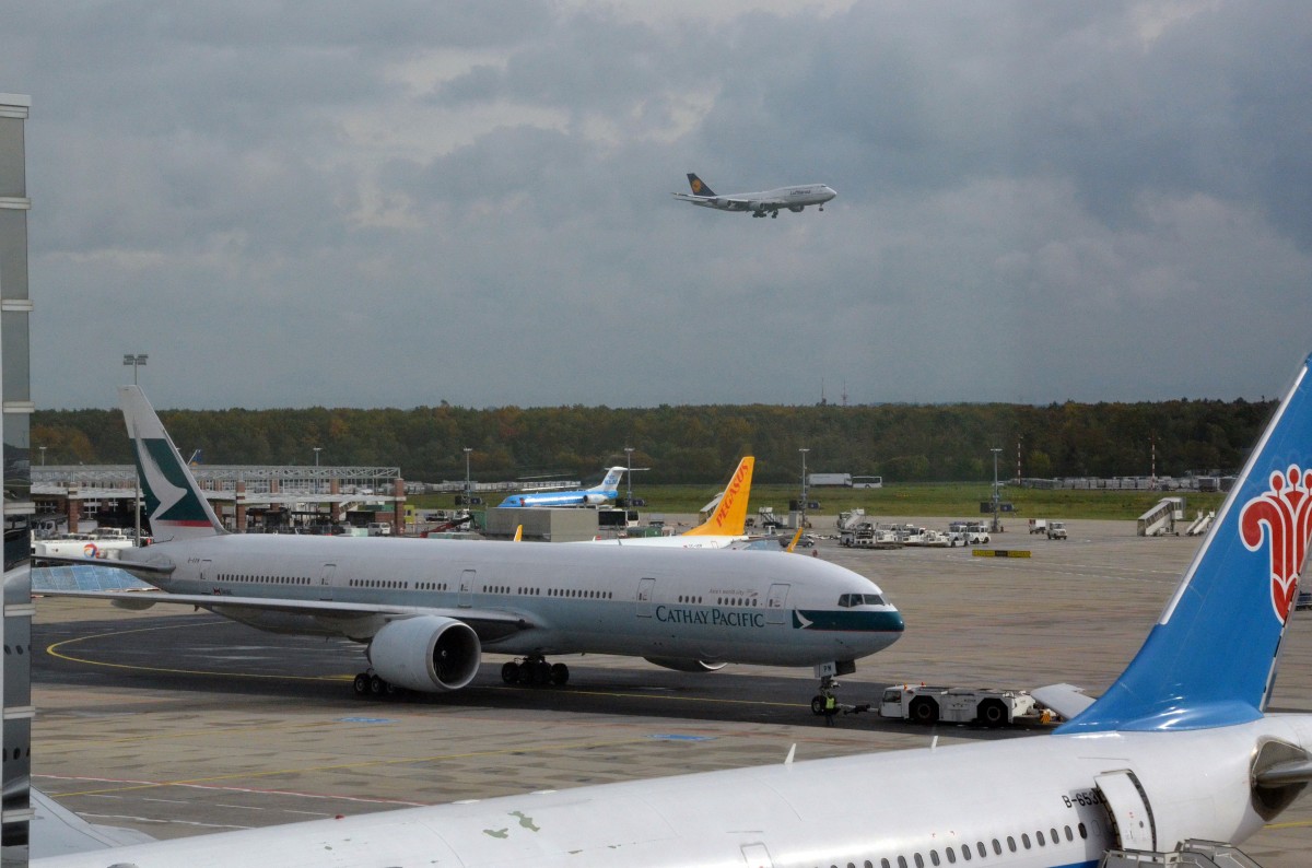 Cathay Pacific Boeing 777-367(ER) B-KPK in Frankfurt /Main  zum Start bereit am 16.10.2014. Über dieser Maschine setzt gerade  die  Lufthansa Boeing 747-430 D-ABVL zur Landung an.