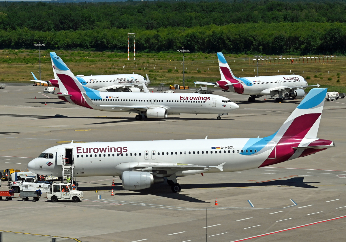 Ein  Rudel  Eurowings von drei A 320 und einer B 737 auf dem Vorfeld von CGN. Vorne A 320 D-ABZL, in der Mitte am rollen die B 737 D-ABWQ, dahinter abgestellt 2 A 320. Flughafen Köln/Bonn 04.07.2022