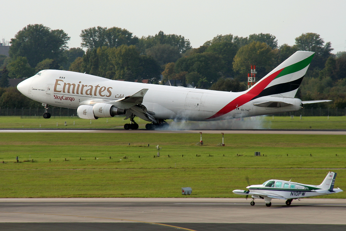 TNT / Emirates Sky Cargo B747-400F OO-THD beim Touchdown auf 23R und Beech A36 N10PW beim Start auf 23L in DUS / EDDL / Düsseldorf am 26.09.2011