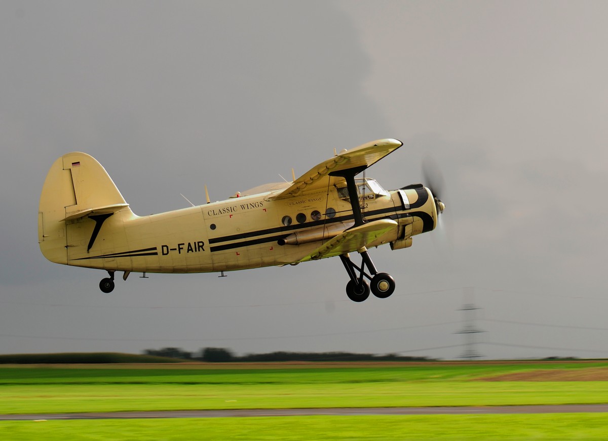 Trotz Gewitter hebt die Antanov An-2, D -FAIR von Classic Wings ab. Aufnahme in Merzbrück (EDKA) am 31.8.2014 bei einer Flugschau.